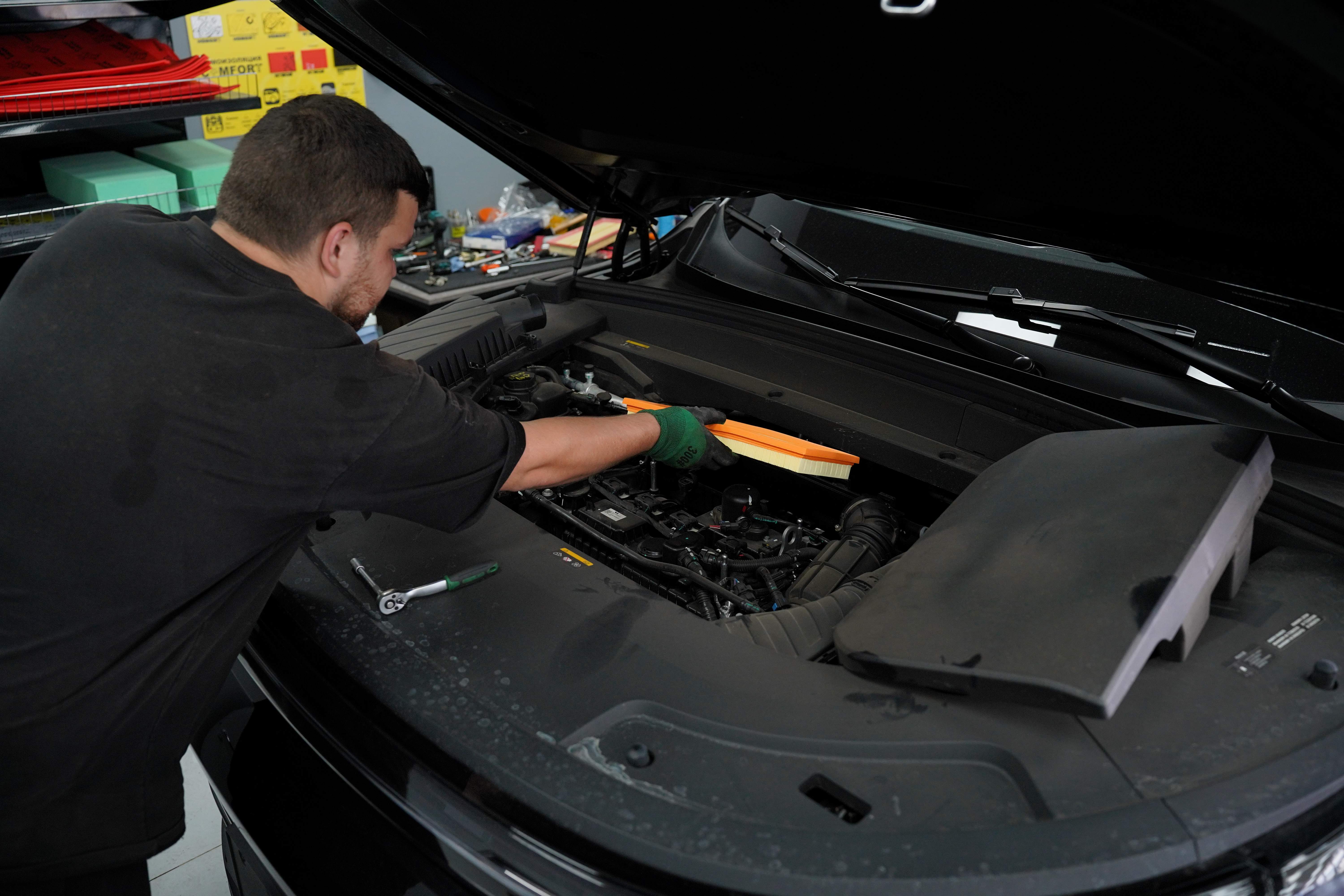 Мастер обслуживает китайский автомобиль в сервисе Electric Cars